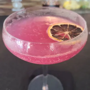 a pink cocktail in a coupe glass