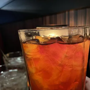 a person holding a glass of iced tea