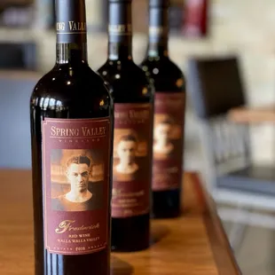 three bottles of wine on a bar