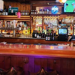 a bar with stools and a television