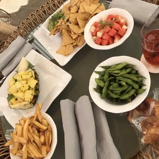 Chips with guac, edamame, watermelon salad, fries, pineapple mint salad