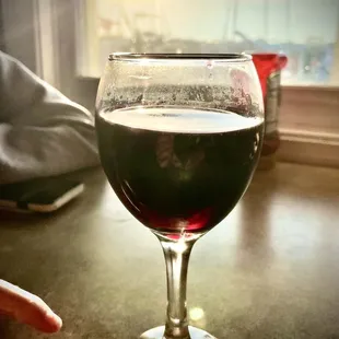 Generous wine pour in a dirty glass.