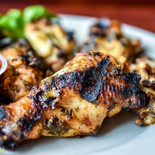 a plate of chicken wings with a side of dipping sauce