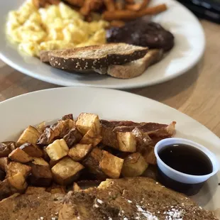 a plate of french toast, eggs, and potatoes