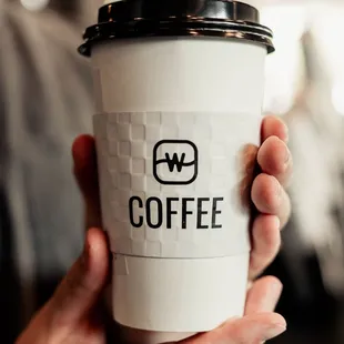 a person holding a coffee cup