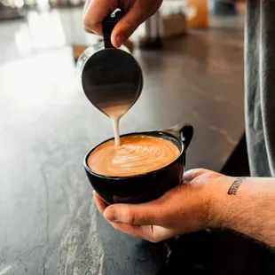 a person pouring coffee into a cup