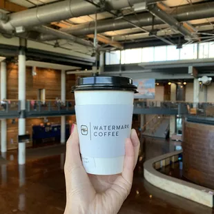 a hand holding a cup of coffee
