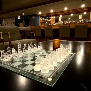 a glass chess board on a wooden table