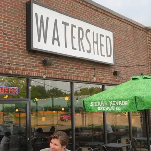a man sitting at a table outside of a restaurant