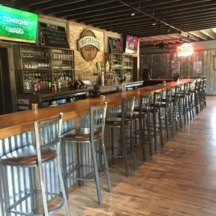 a bar with stools and a television