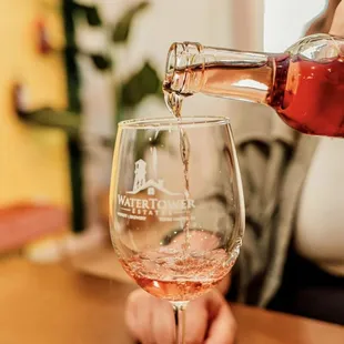 a woman pouring wine into a glass