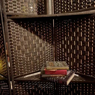 a shelf with books and a vase