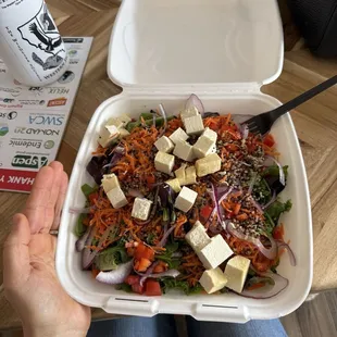 Large mixed green salad with tofu and quinoa.