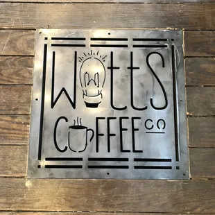 a metal sign on a wooden floor