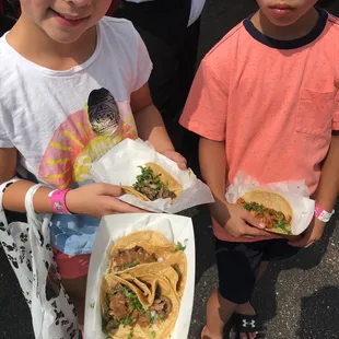 two children holding tacos