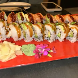 a long roll of sushi on a red plate