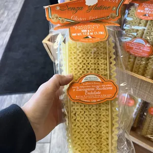 a hand holding a package of noodles