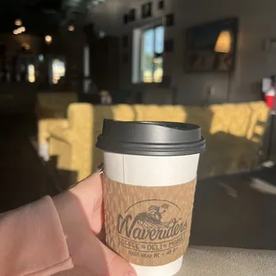 a hand holding a coffee cup