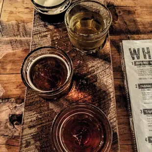 three glasses of beer and a menu