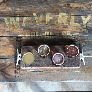 a wooden tray with five different beers