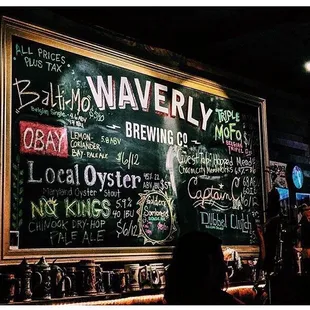 a chalkboard with a variety of beers