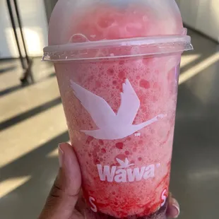 a hand holding a cup of frozen drink