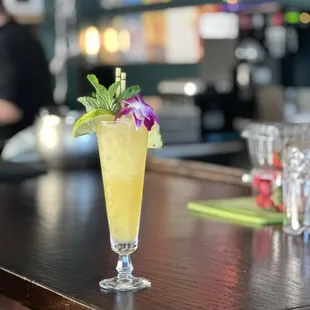 a glass of cocktail on a bar