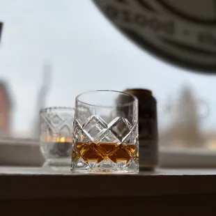 a glass of whiskey on a window sill