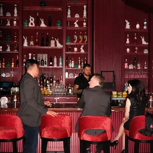 three people sitting at a bar