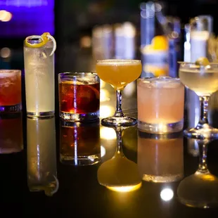 a variety of cocktails on a bar