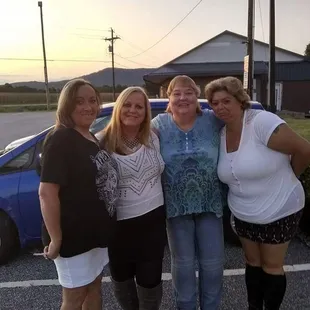 a group of women standing in a parking lot