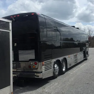 a black bus parked in a parking lot