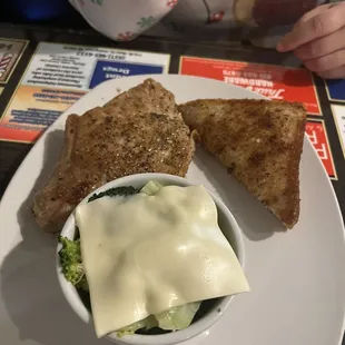 &quot;Butcher Day&quot; Pork Chop A 12 oz. thick cut, Dutch chop topped with fresh pineapple, includes one side, and bread with broccoli &amp; cheese