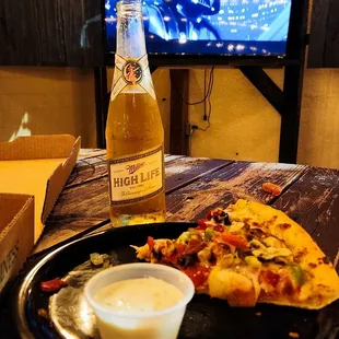 a bottle of beer and a slice of pizza