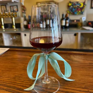 a glass of red wine on a bar