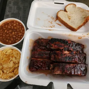  a tray of ribs, beans, and bread