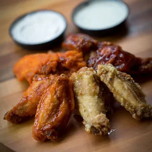 a plate of chicken wings and dips