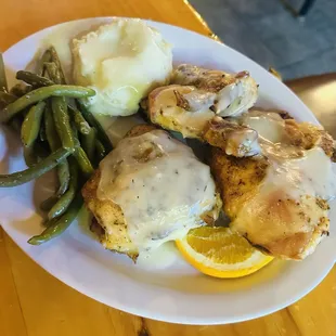 1/2 backed chicken with homemade gravy over the top paired with mashed potato's and green bean's.