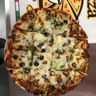 a pizza with olives, peppers, and cheese