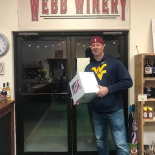 a man holding a box of wine