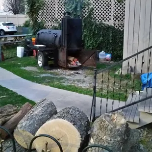 Wood in the foreground, smoker in the background
