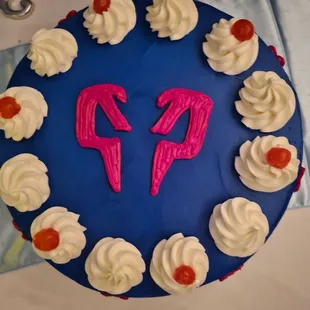 a blue cake with white frosting and a pink number