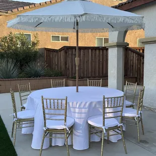 Fringe umbrella with 72" round table and chiavari chairs