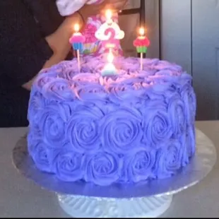 a woman blowing out candles on a cake