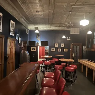 a row of red stools in a bar