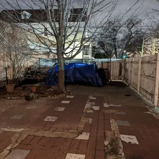 an empty patio with a blue tarp covering it