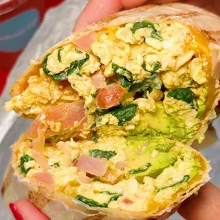 a person holding a breakfast burrito