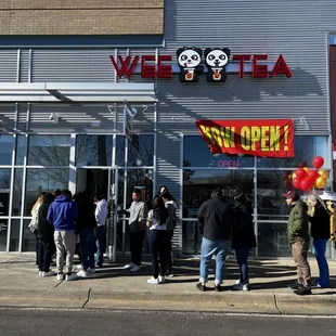 a group of people standing outside of a store