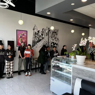 a group of people standing in a coffee shop