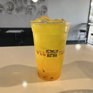 a yellow drink in a plastic cup